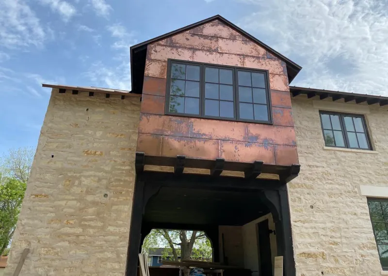 Copper metal panel facade on a stone building for Skylight Installation in Lake City